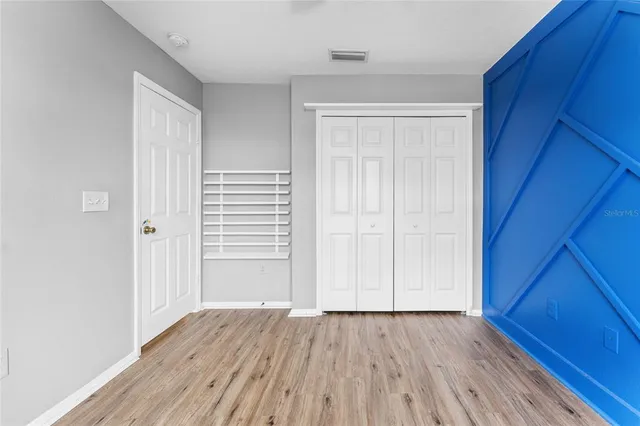 an empty room with wooden floor and closet
