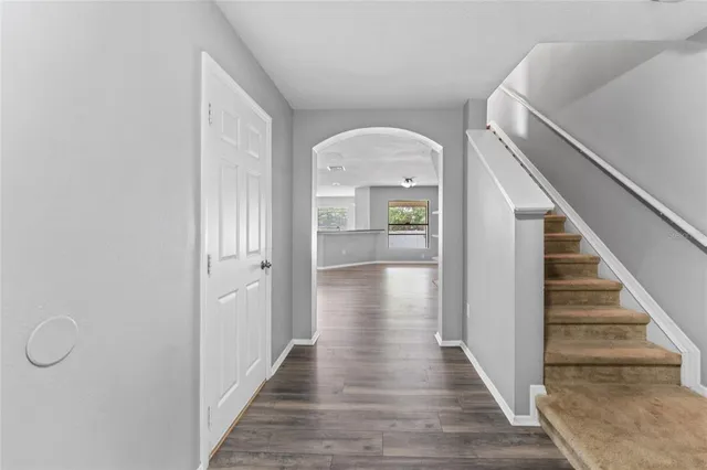 a view of a hallway with wooden floor and staircase