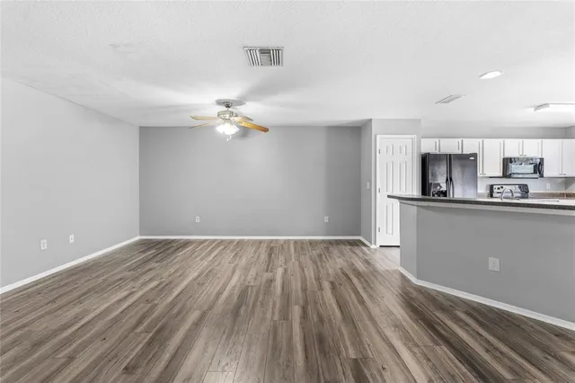 a view of a kitchen with a sink and dishwasher with wooden floor