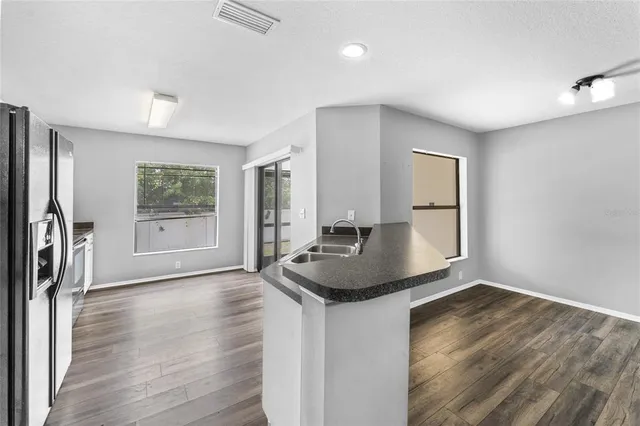a kitchen with granite countertop a sink and a stove top oven