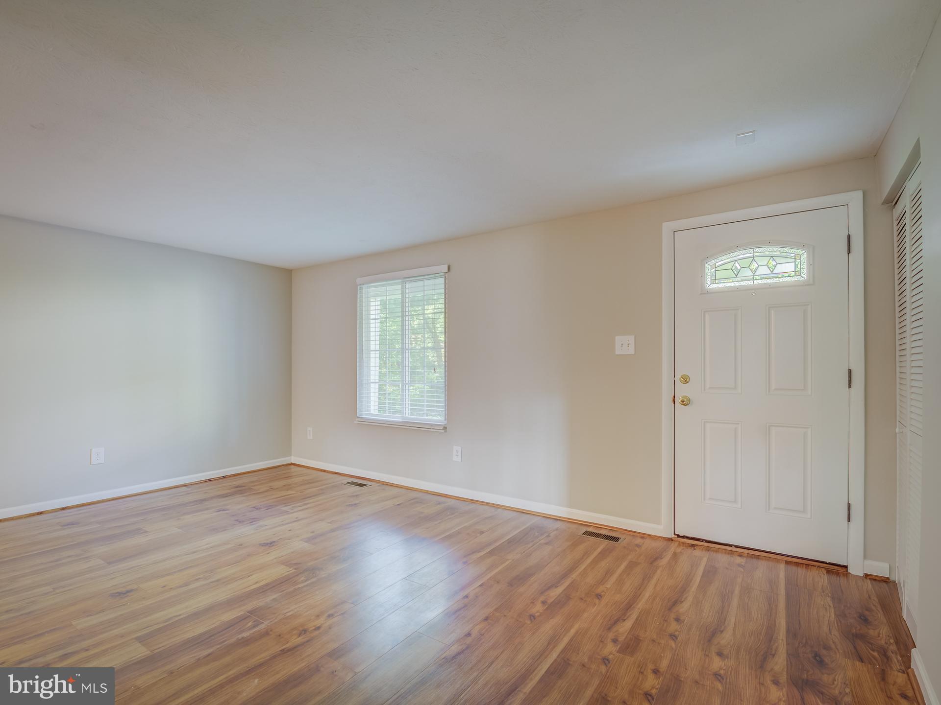 10833 Split Oak Lane Burke, VA 22015 - Photo 7 of 47 a view of an empty room with wooden floor and a window