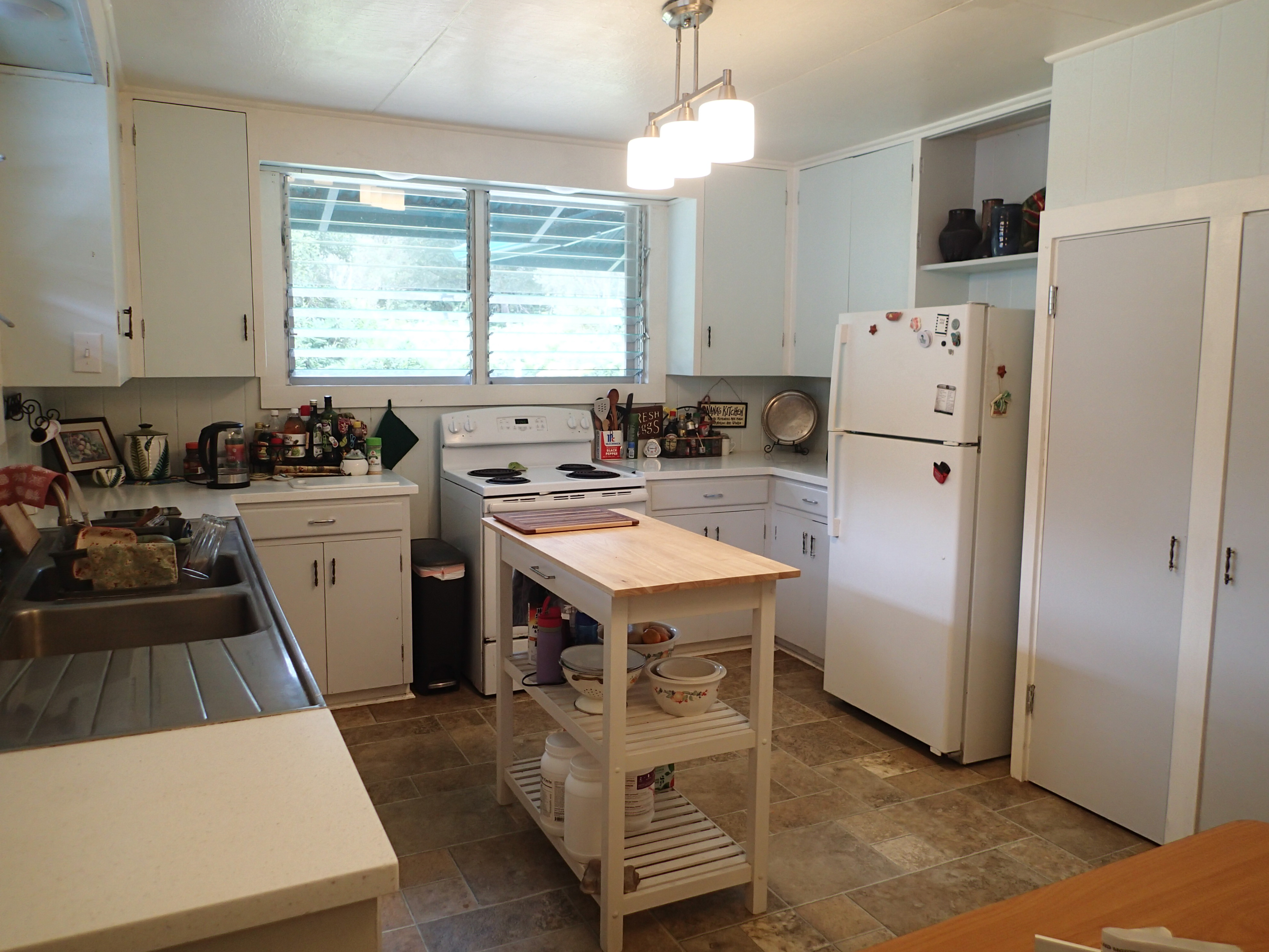 17-4100 Kukui Camp Road Kurtistown, HI 96760 - Photo 8 of 25 a kitchen with a sink a refrigerator a stove a washer and a window