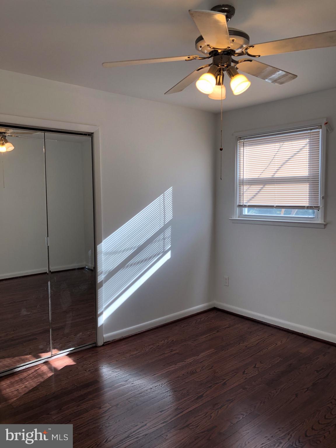10005 Riggs Road Adelphi, MD 20783 - Photo 12 of 32 an empty room with wooden floor and windows