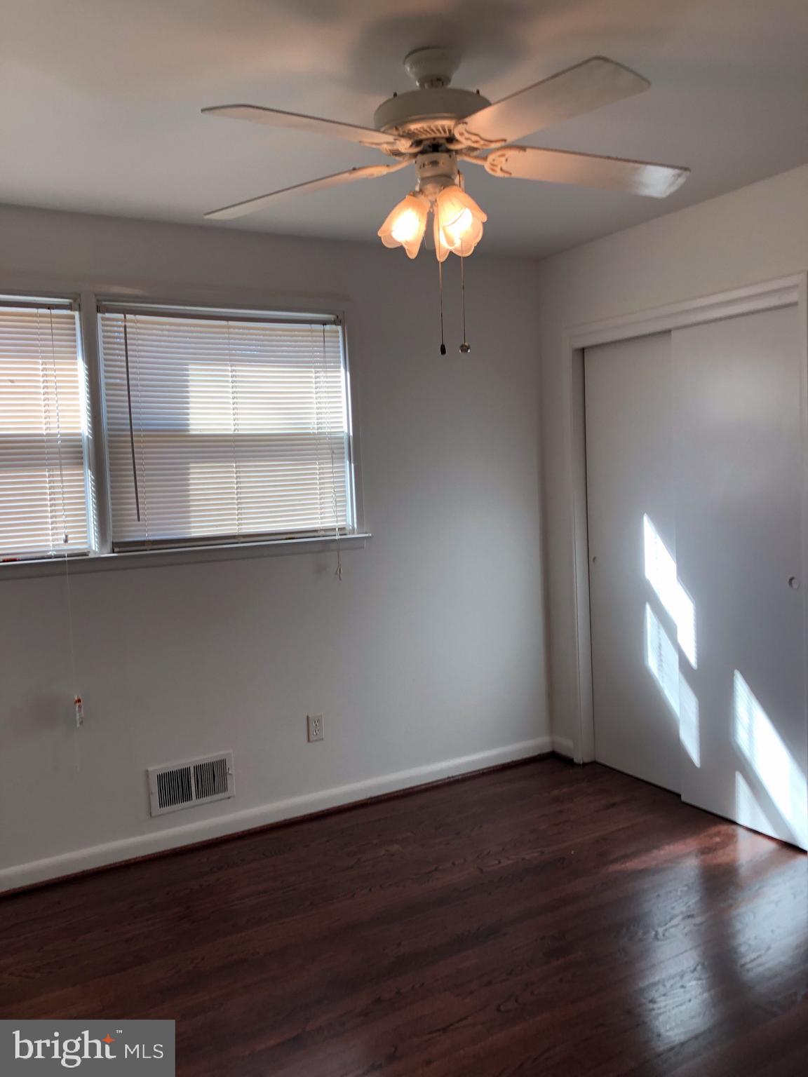 10005 Riggs Road Adelphi, MD 20783 - Photo 13 of 32 an empty room with wooden floor and windows