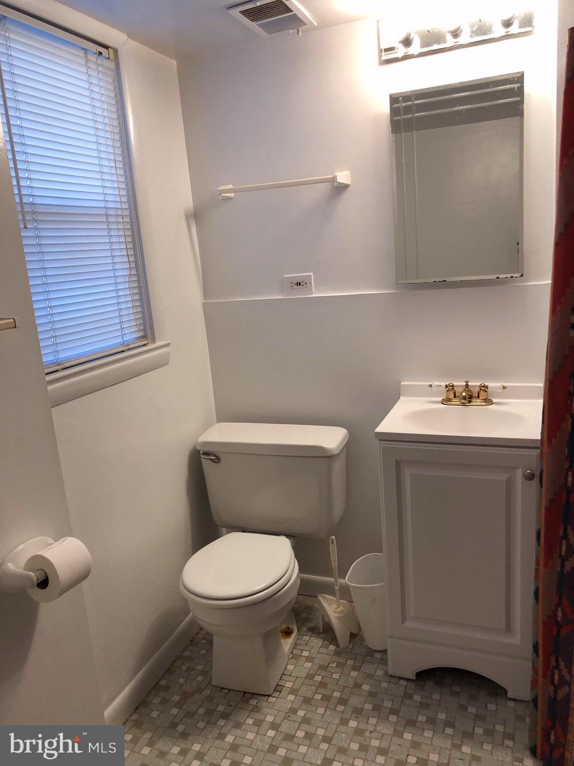 10005 Riggs Road Adelphi, MD 20783 - Photo 22 of 32 a white toilet sitting next to a bathroom sink