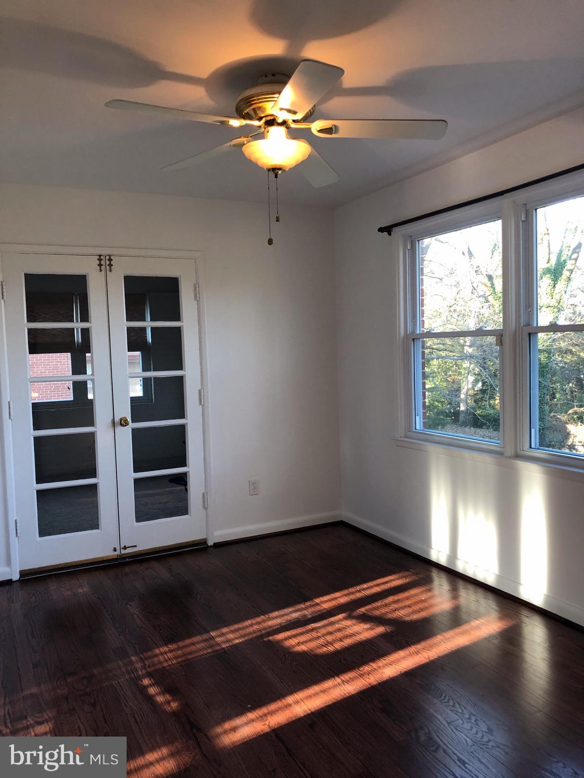 10005 Riggs Road Adelphi, MD 20783 - Photo 4 of 32 a view of an empty room with a window and wooden floor