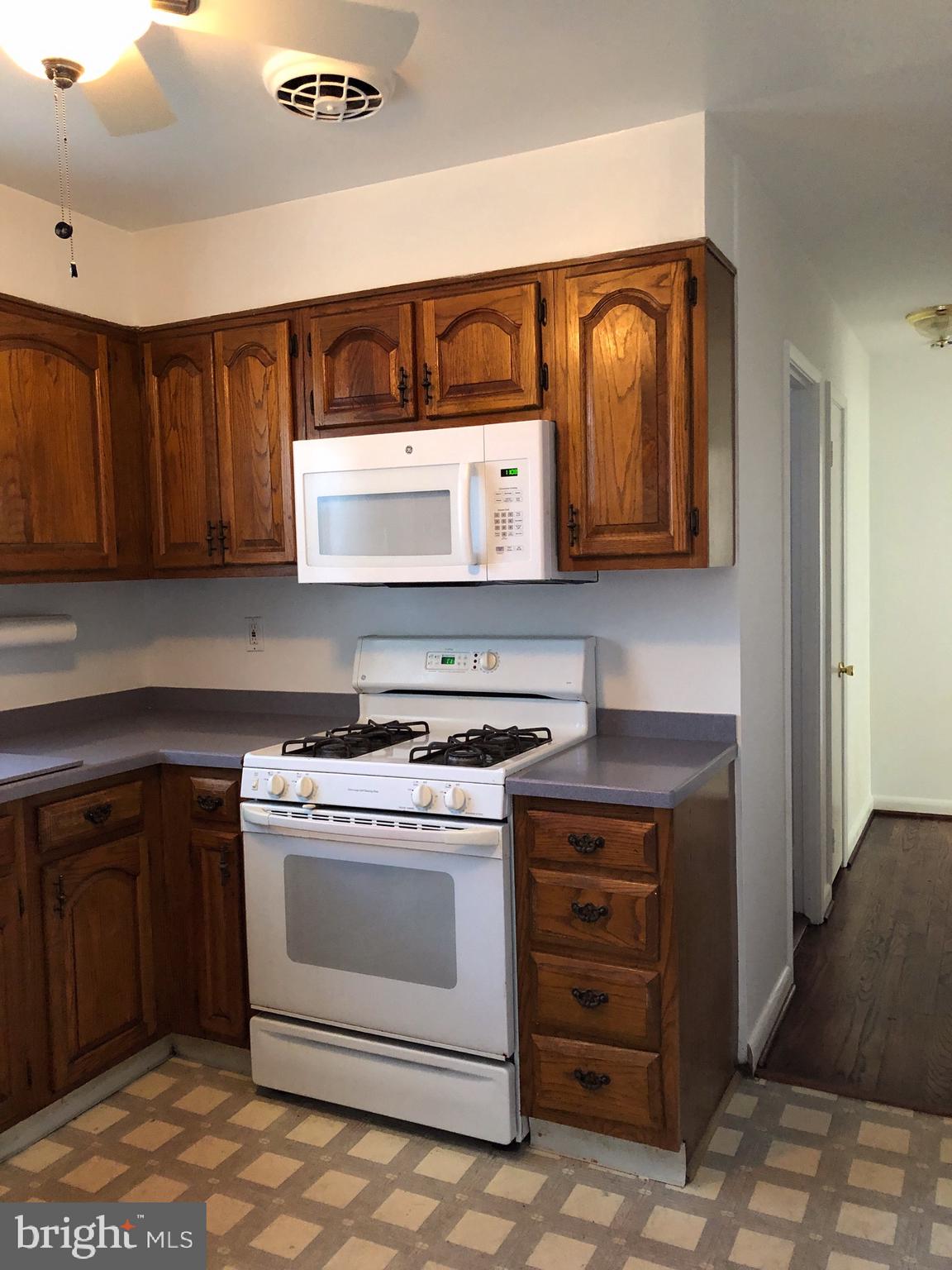10005 Riggs Road Adelphi, MD 20783 - Photo 6 of 32 a kitchen with a stove and a microwave