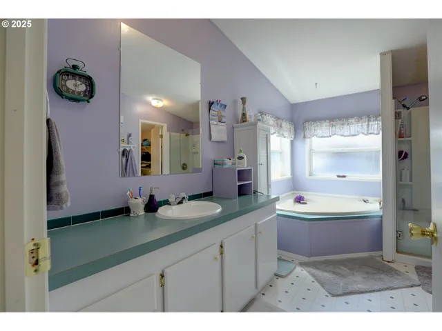 a bathroom with a granite countertop sink mirror and bathtub