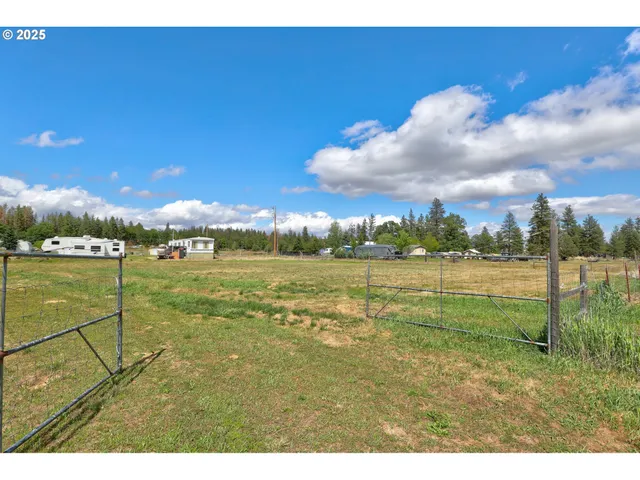 a view of swimming pool with lawn chairs and iron fence