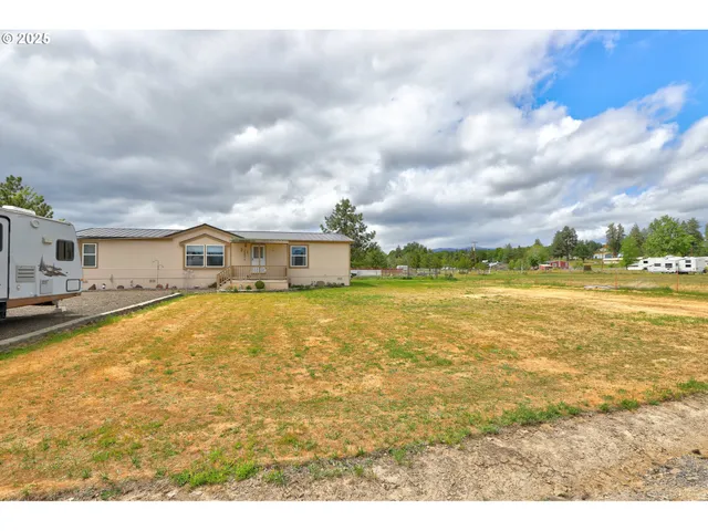 a view of a house with backyard and sitting area