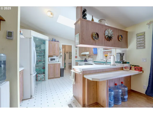 a view of a kitchen with refrigerator and wooden floor