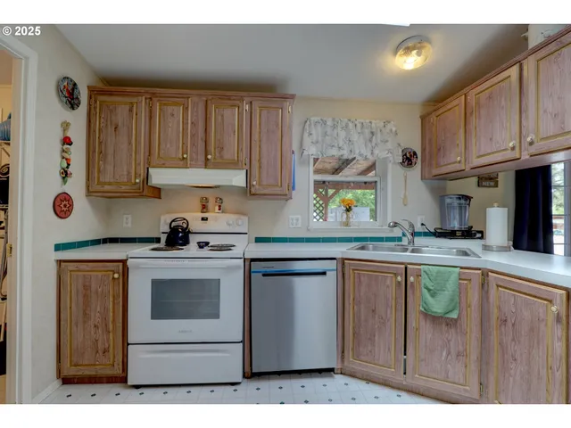 a kitchen with stainless steel appliances granite countertop a sink a stove a refrigerator and cabinets