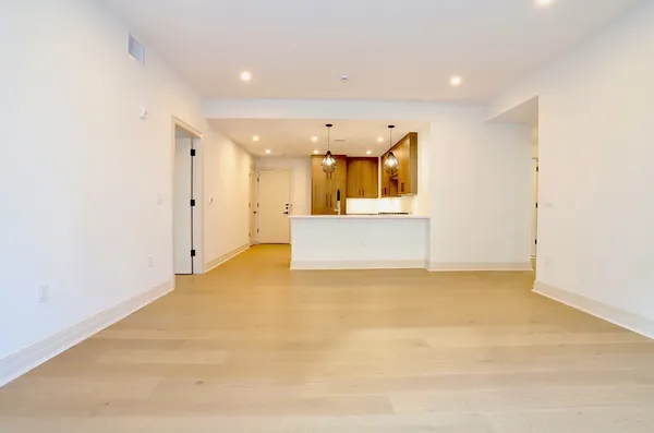 a view of an empty room with a kitchen