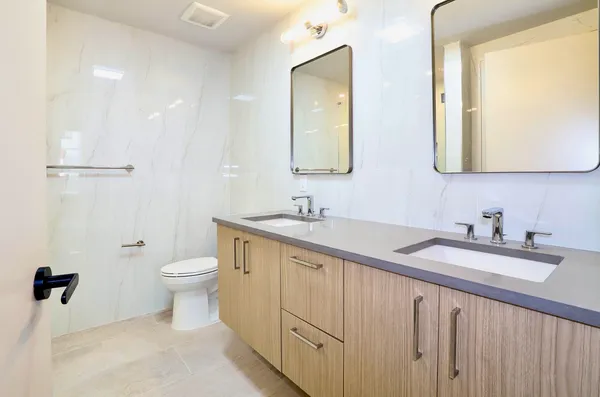 a bathroom with a sink a toilet and mirror