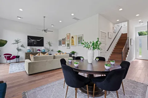 a kitchen with a dining table chairs and wooden floor