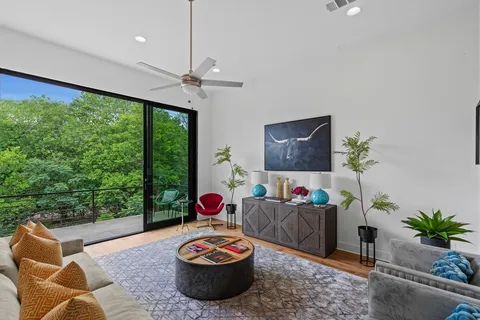 a kitchen with sink refrigerator and couches with wooden floor