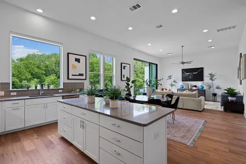 a kitchen with stainless steel appliances kitchen island granite countertop a stove a sink a refrigerator and cabinets