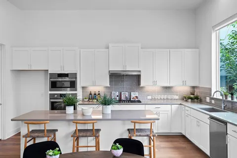 a kitchen with stainless steel appliances granite countertop a sink a stove and a wooden floors