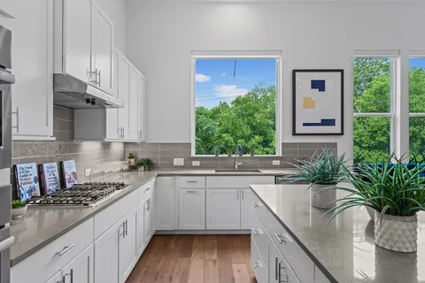 a kitchen with stainless steel appliances a stove a sink a microwave a refrigerator and cabinets