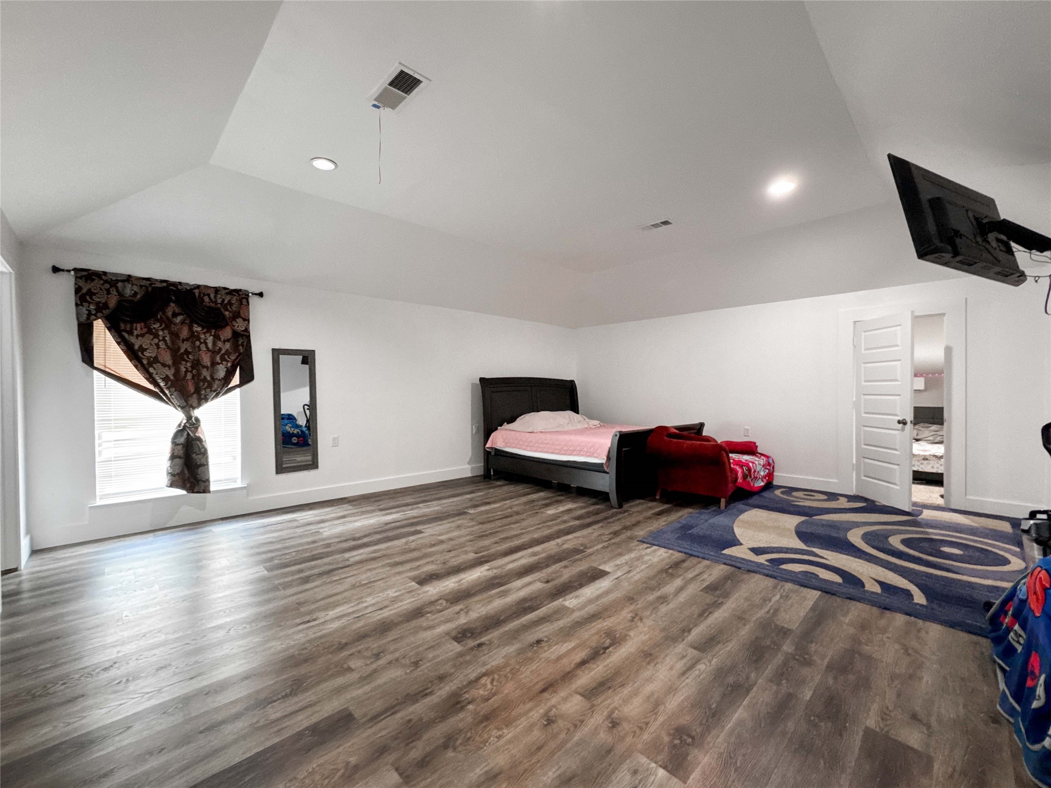 1060 County Road 5021 Cleveland, TX 77327 - Photo 18 of 34 a spacious bedroom with a bed and wooden floor