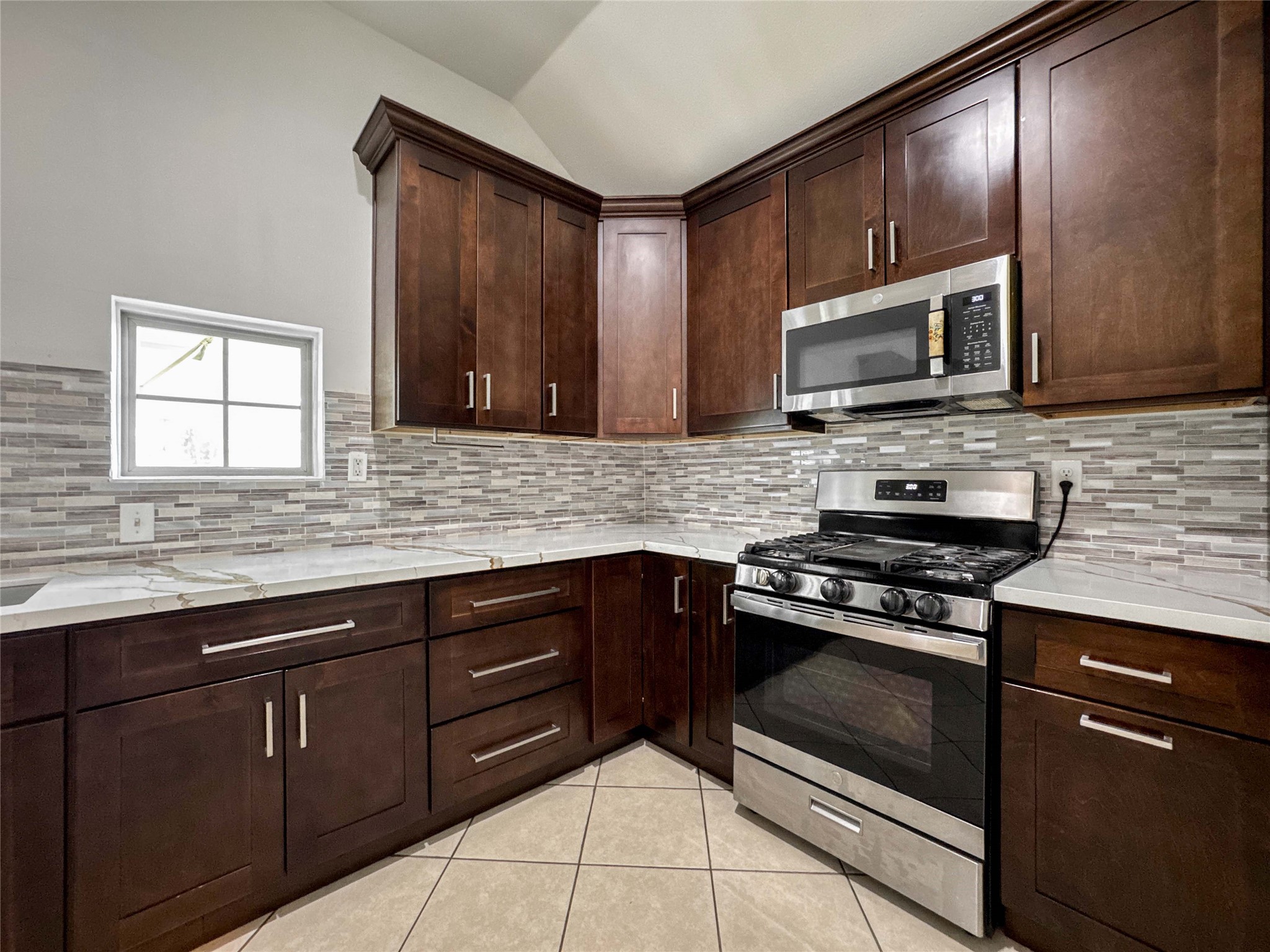 1060 County Road 5021 Cleveland, TX 77327 - Photo 8 of 34 a kitchen with stainless steel appliances granite countertop wooden cabinets stove top oven and microwave