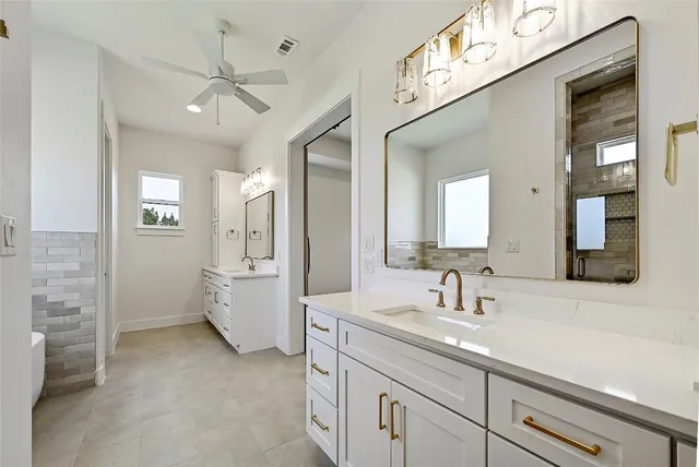 a spacious bathroom with a double vanity sink a mirror and shower