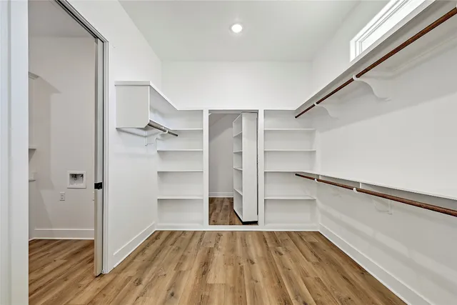 a view of walk in closet with wooden floor
