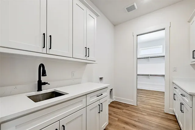 a view of cabinets a sink and dishwasher in a white cabinet