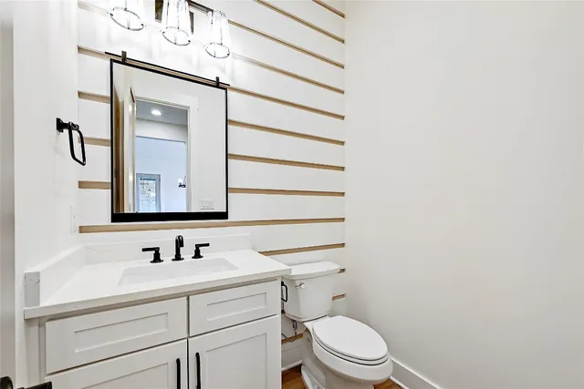 a bathroom with a sink vanity mirror and toilet