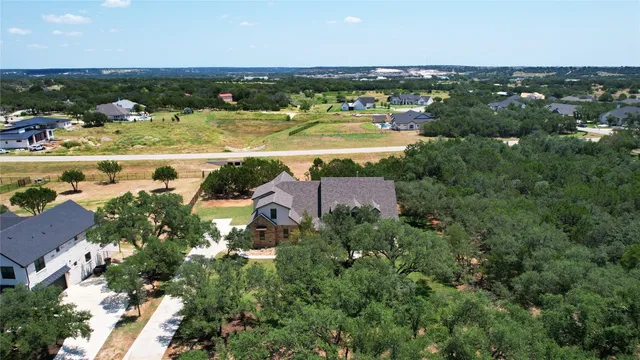 an aerial view of ocean and residential houses with outdoor space