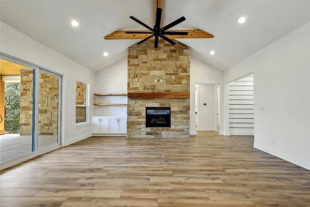 a view of an empty room with a fireplace and a window