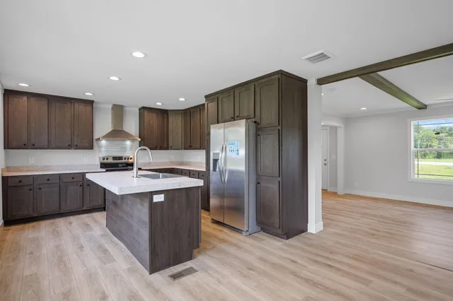 a kitchen with a sink cabinets stainless steel appliances and a window