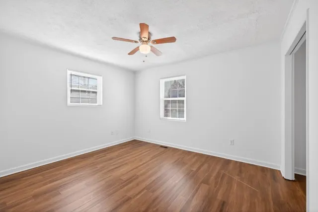 a view of a room with wooden floor and windows