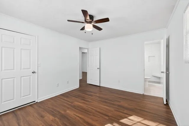 a view of empty room with wooden floor and ceiling fan