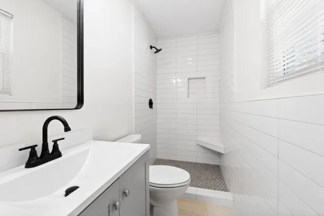 a bathroom with a sink a toilet and a mirror