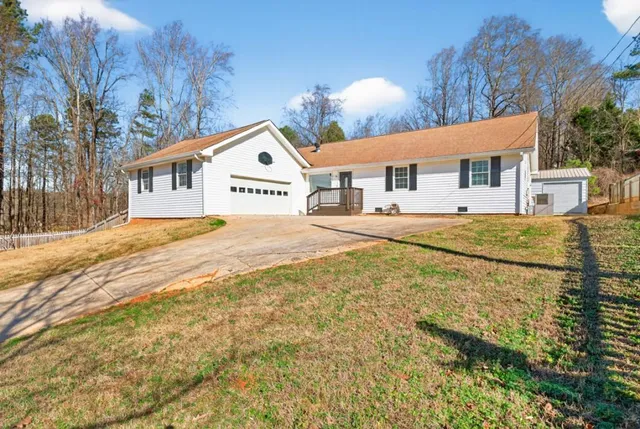 a front view of a house with a yard and road