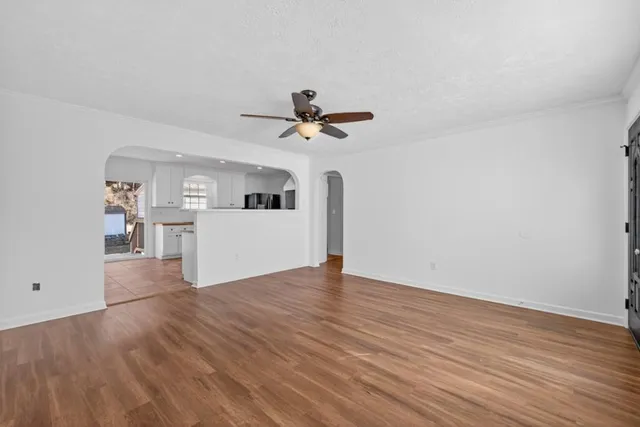 a view of a kitchen with wooden floor and a ceiling fan