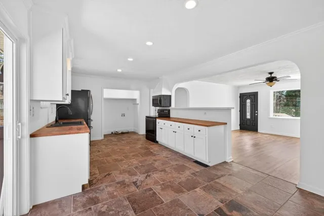 a kitchen with stainless steel appliances kitchen island granite countertop a refrigerator and a stove top oven