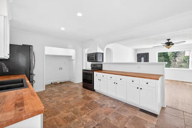 a kitchen with granite countertop a stove a sink and a refrigerator