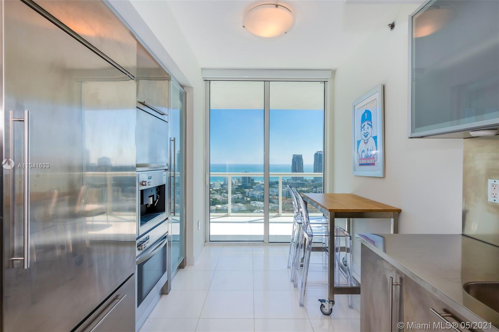 450 Alton Road, Unit 3207 Miami Beach, FL 33139 - Photo 12 of 31 a kitchen with stainless steel appliances refrigerator and table