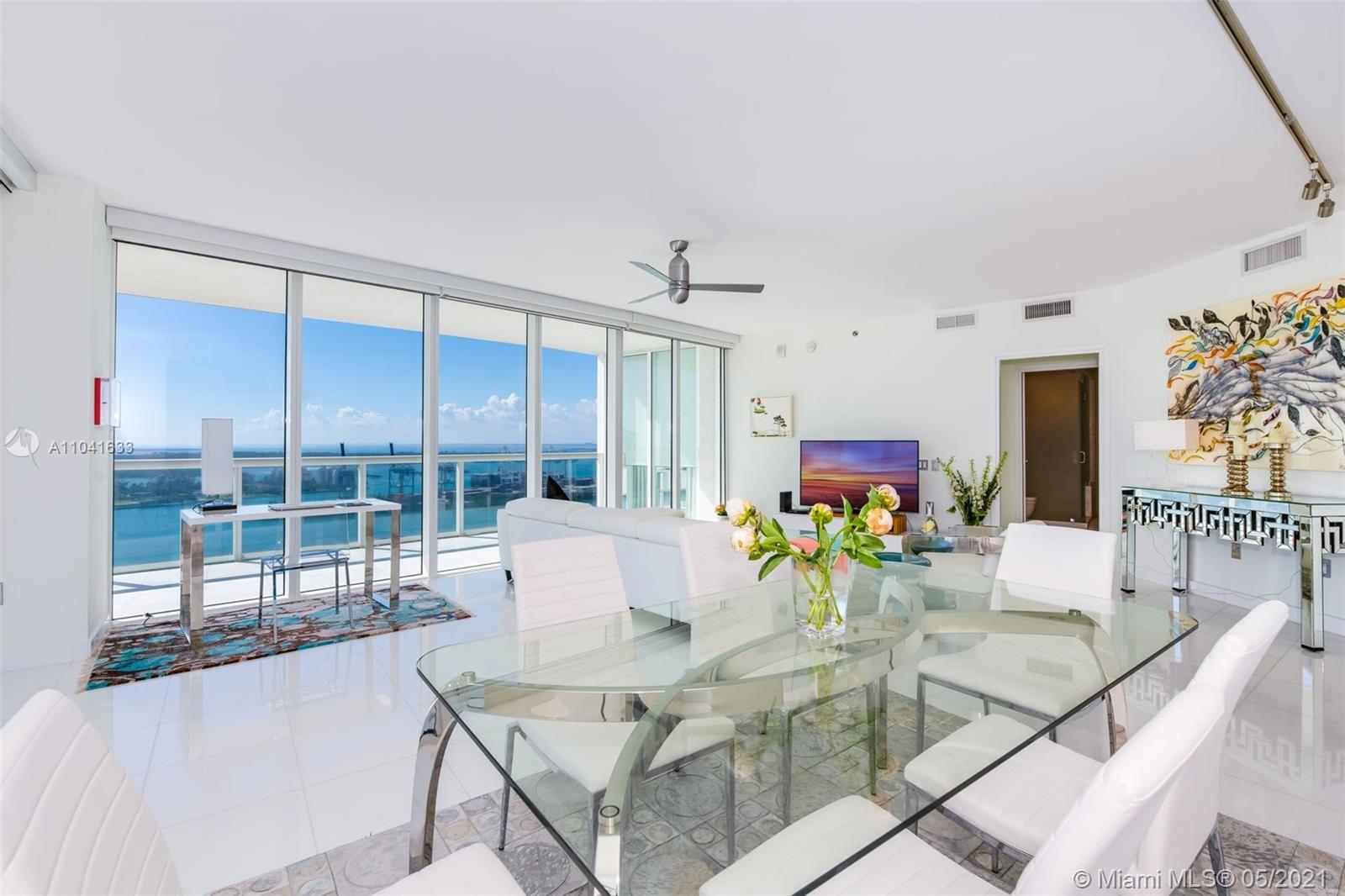 450 Alton Road, Unit 3207 Miami Beach, FL 33139 - Photo 3 of 31 a view of a dining room with furniture a chandelier and wooden floor