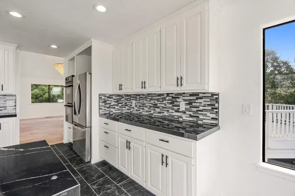 a kitchen with stainless steel appliances kitchen island granite countertop a sink and cabinets