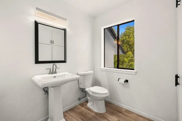 a view of a livingroom with wooden floor and a fireplace
