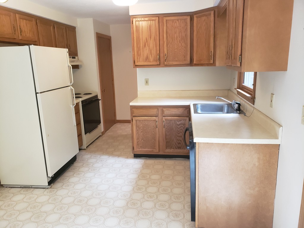 68 Lawton Road, Unit B Shirley, MA 01464 - Photo 5 of 14 a kitchen with a refrigerator sink stove and cabinets