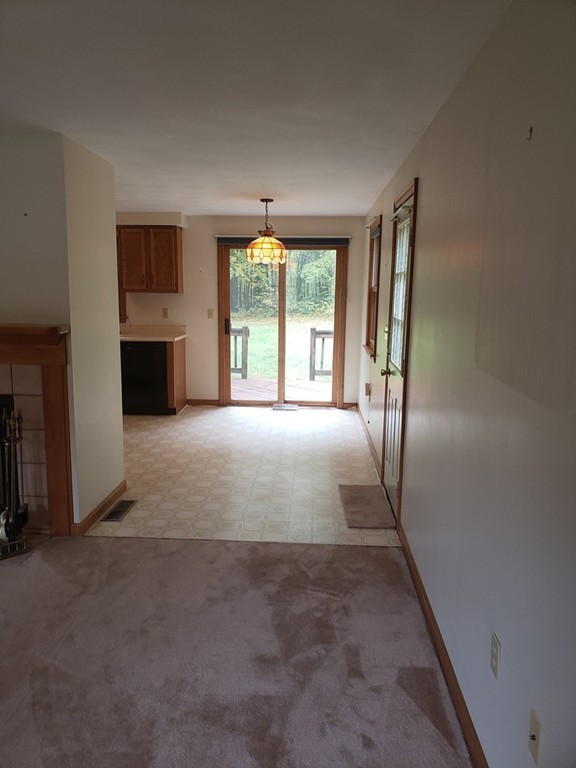 68 Lawton Road, Unit B Shirley, MA 01464 - Photo 6 of 14 a view of an empty room with a fireplace and a window