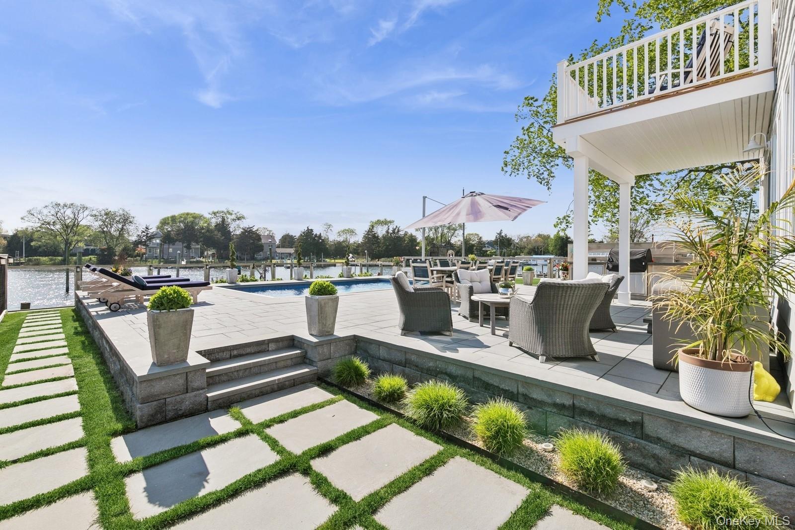 81 Beach Road Aquebogue, NY 11901 - Photo 15 of 34 a view of a chairs and table in patio with a lake view