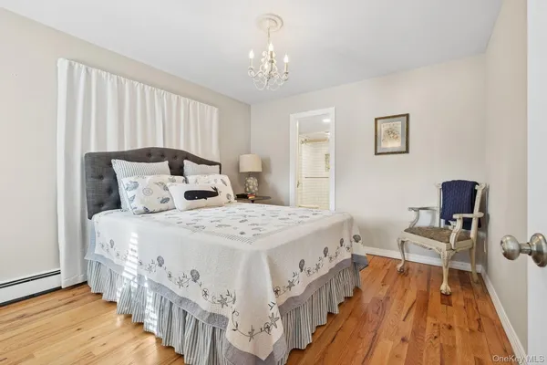 a bedroom with a bed table chair and a window
