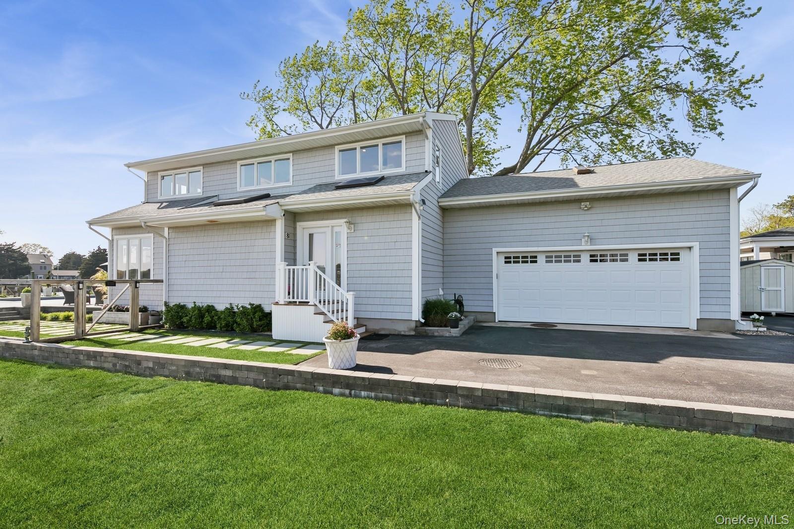 81 Beach Road Aquebogue, NY 11901 - Photo 34 of 34 a front view of a house with a yard and garage