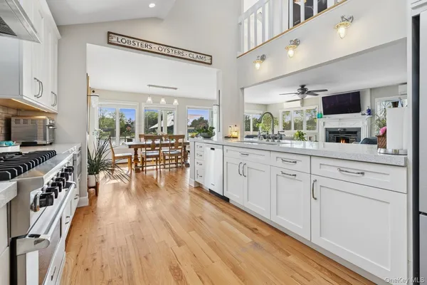 a kitchen with stainless steel appliances a microwave a stove and white cabinets with wooden floor