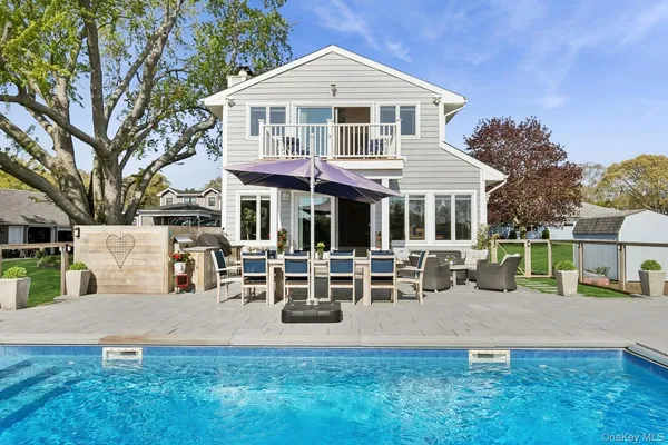 a front view of a house with garden and sitting area
